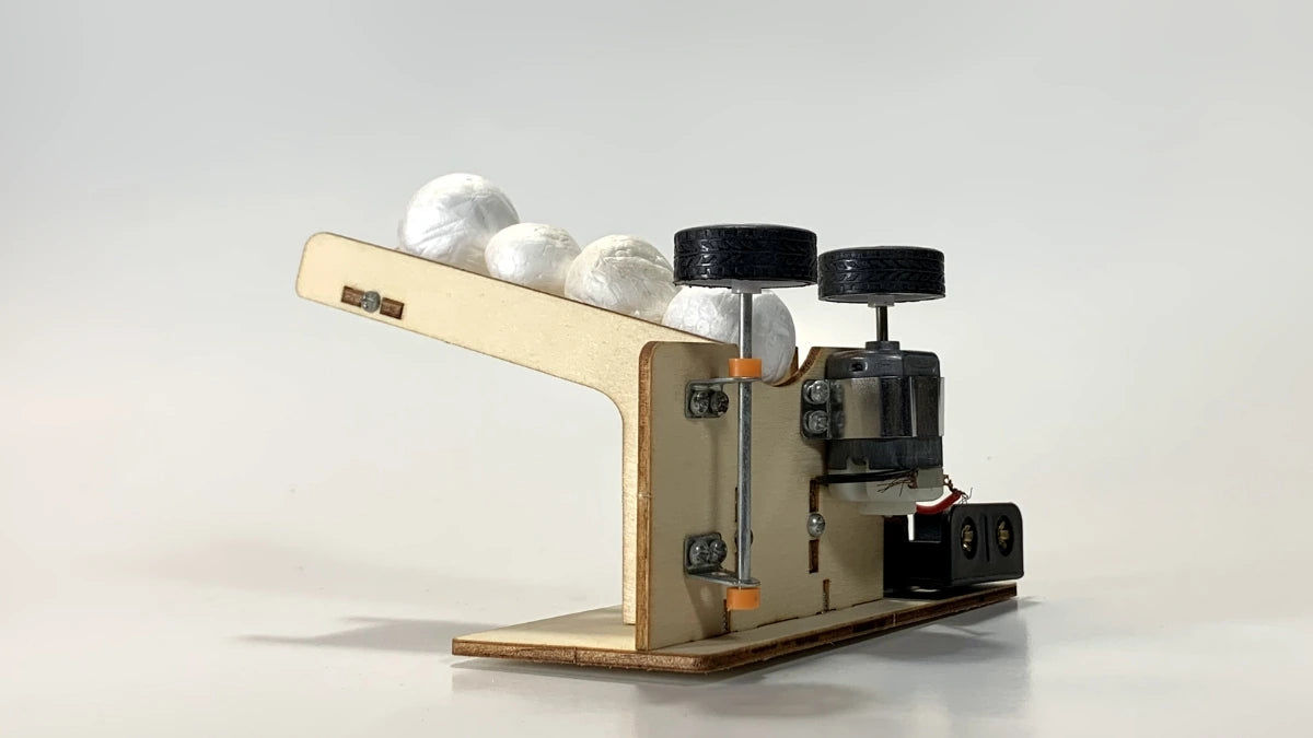 Side view of the Ball Pitching Machine STEM Kit, showing the motorized mechanism, wooden components, and battery compartment for hands-on STEM education.