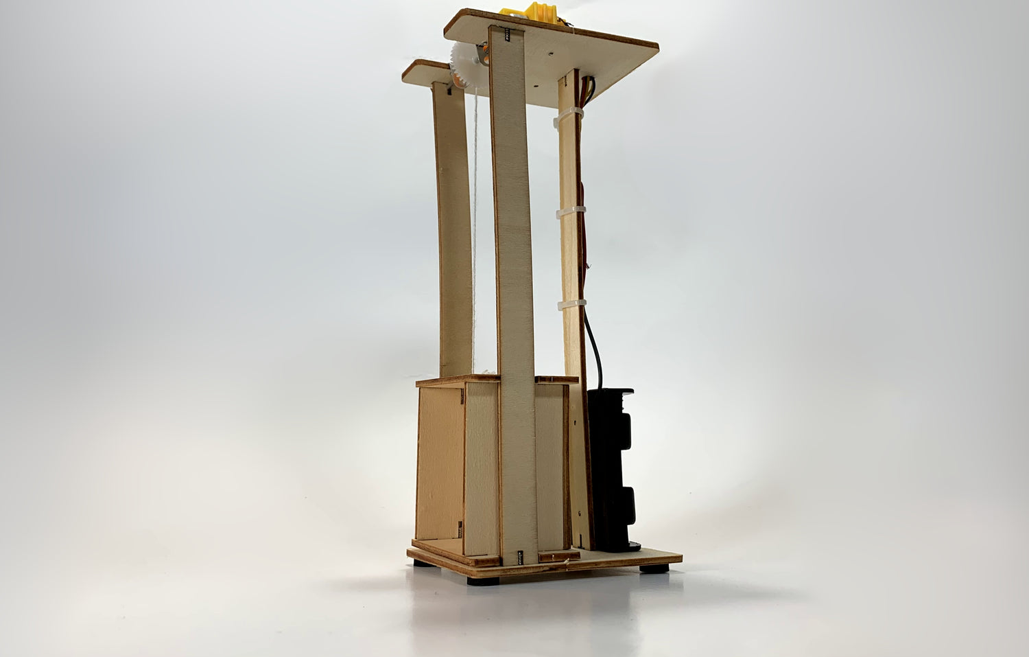 Side Angled View of Electric Elevator STEM Kit – Wooden DIY Model with Pulley System, Battery Pack, and Wiring for STEM Learning