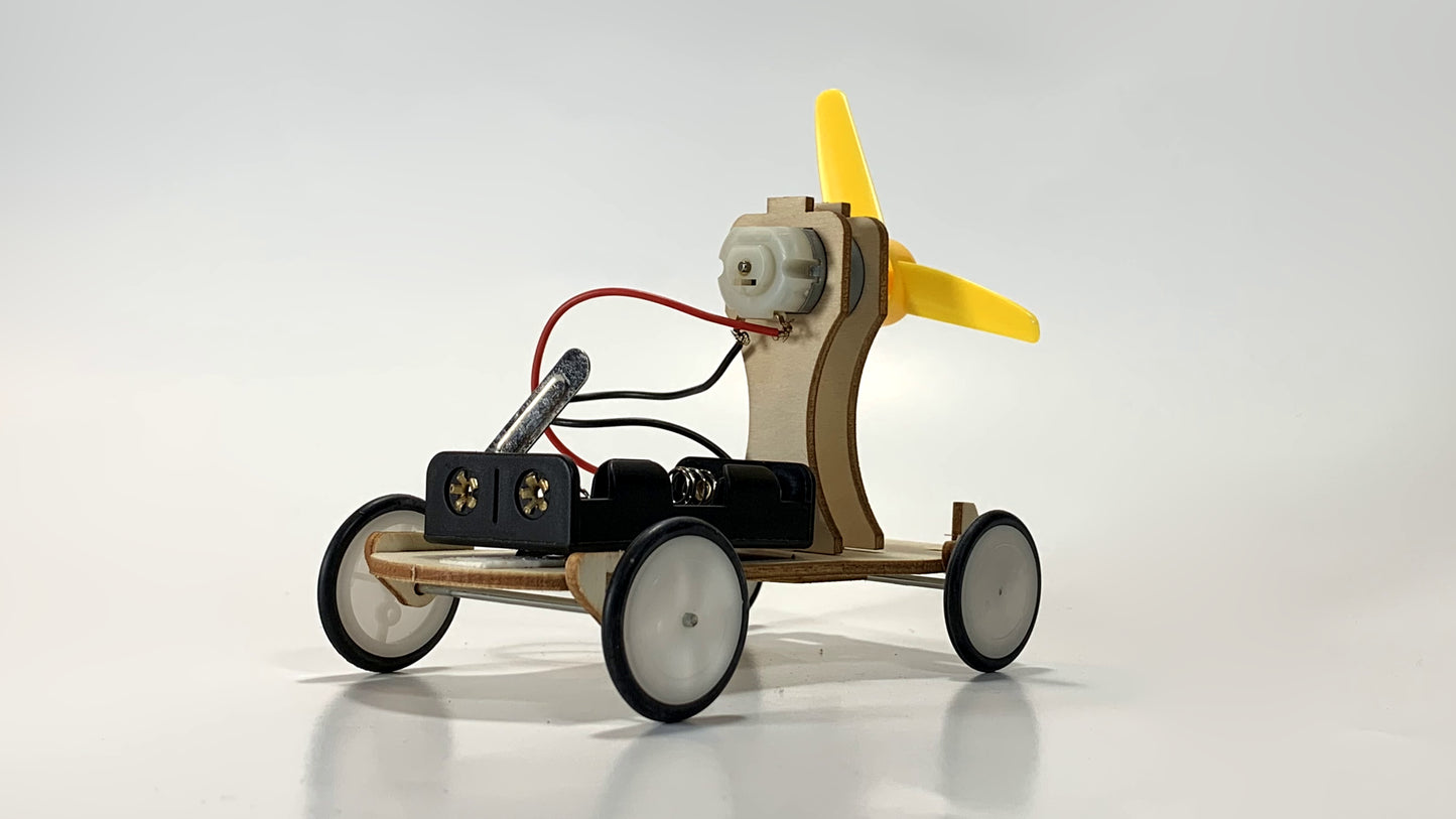 Angled Side View of Electric Wind Car STEM Kit – Wooden DIY Model with Yellow Propeller, Motor, and Battery Pack for STEM Learning