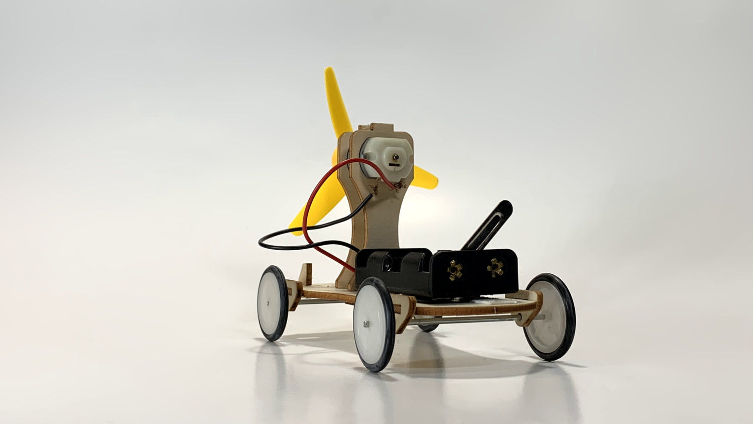 Front View of Electric Wind Car STEM Kit – Wooden DIY Model with Yellow Propeller, Motor, and Battery Pack for STEM Education