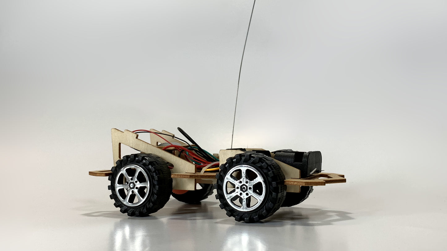 Remote Control Race Car STEM Kit showcasing side view with exposed wiring, antenna, rugged wheels, and wooden chassis