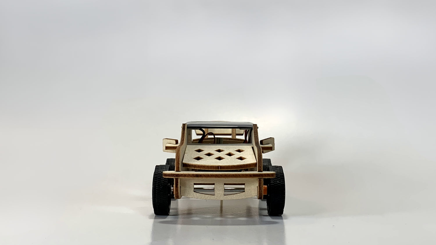 Front view of the Solar-Powered Race Car STEM Kit, featuring a detailed wooden grille, sturdy wheels, and solar panel on top