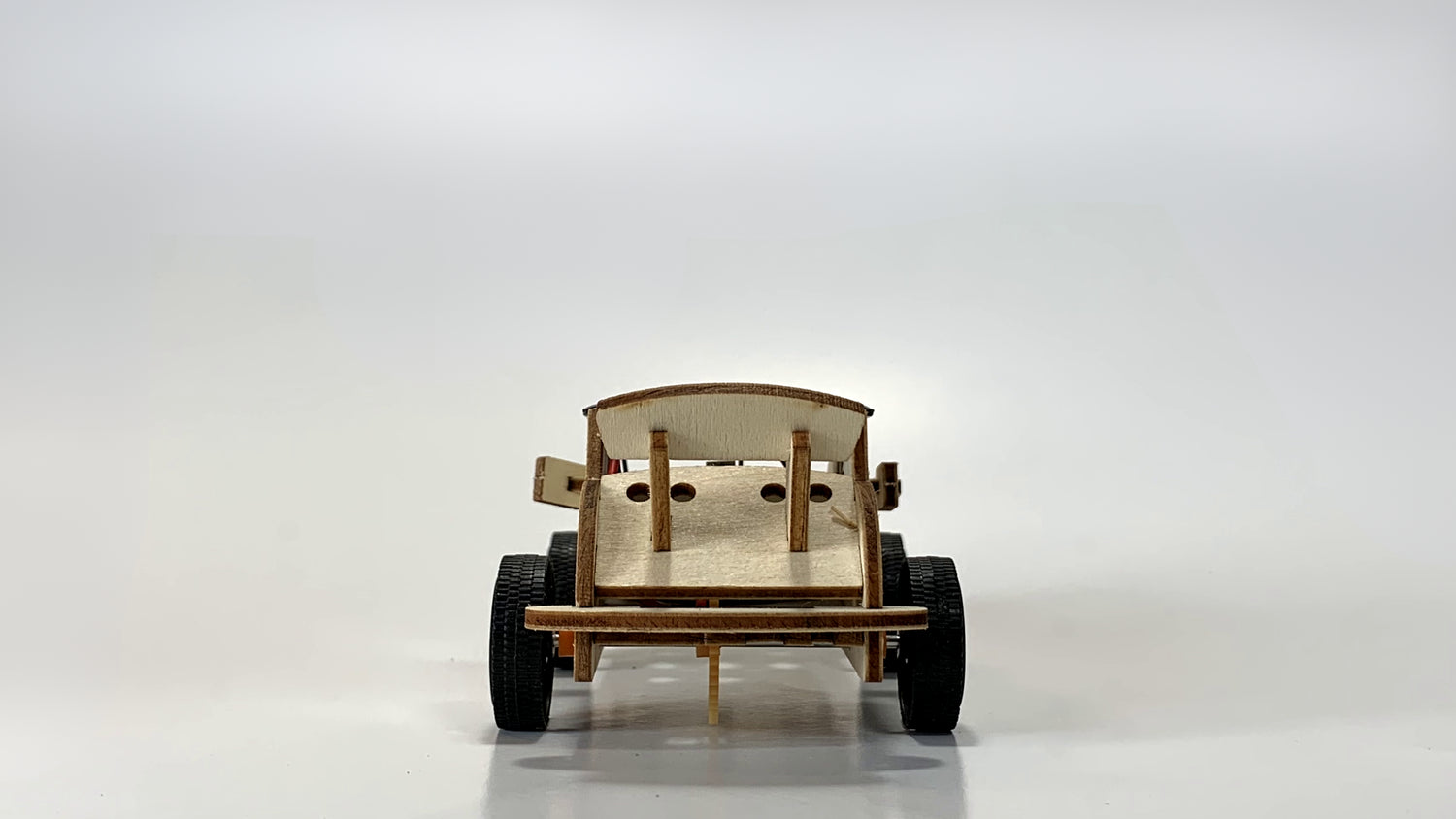 Rear view of the Solar-Powered Race Car STEM Kit, highlighting wooden frame, aerodynamic spoiler, and durable black wheels